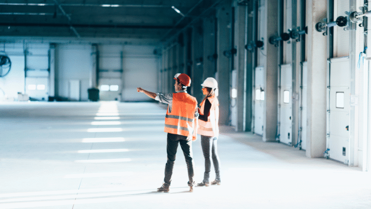 Two facility workers in a manufacturing facility.