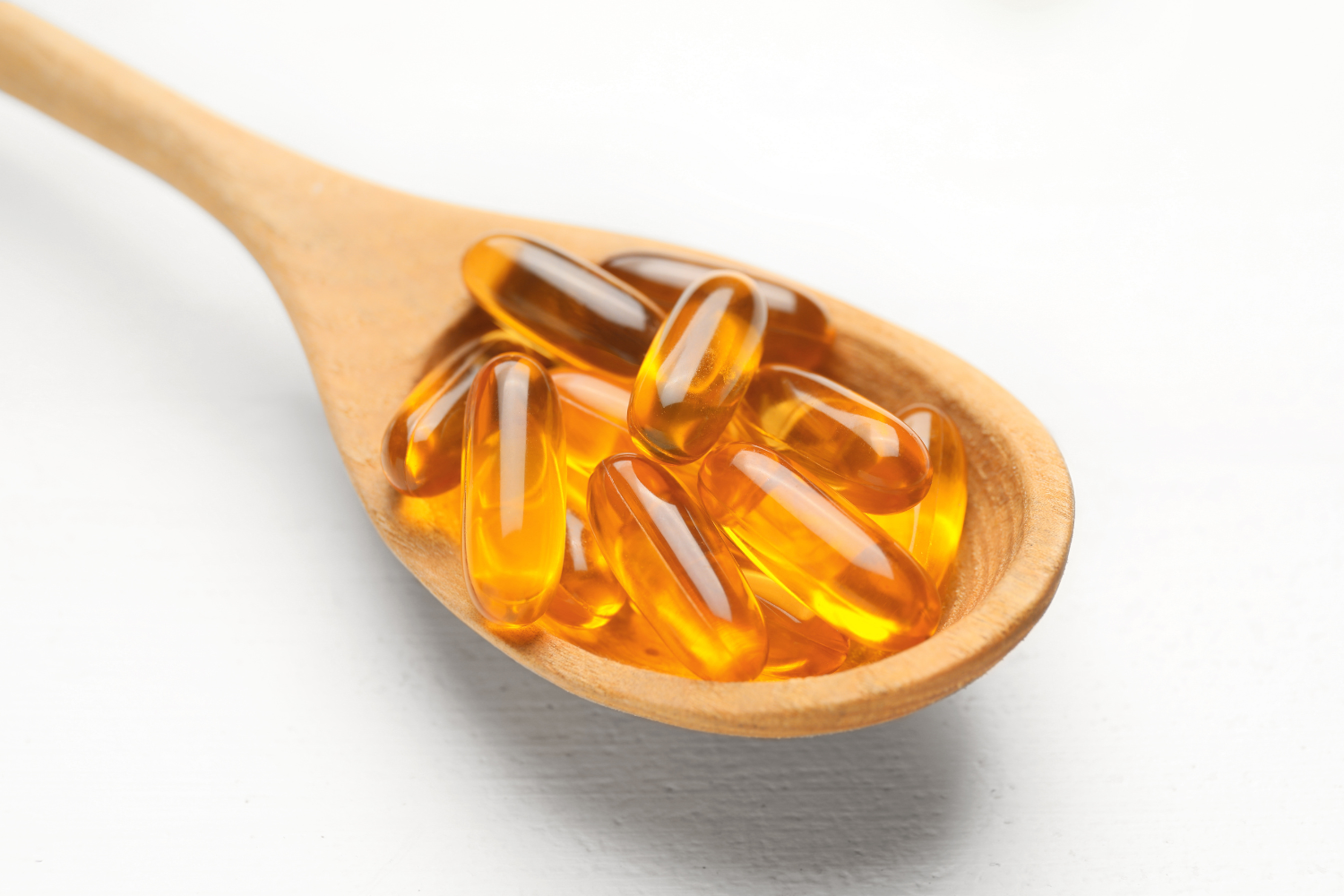 Softgels in a wooden spoon.
