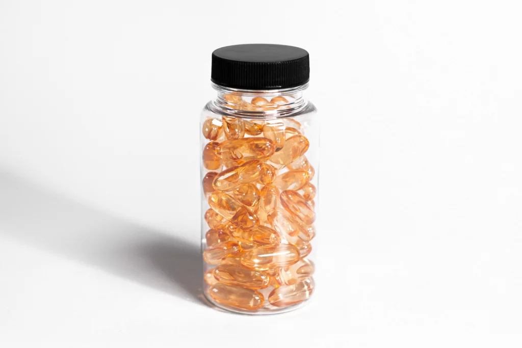 Clear glass supplement bottle with supplements inside.