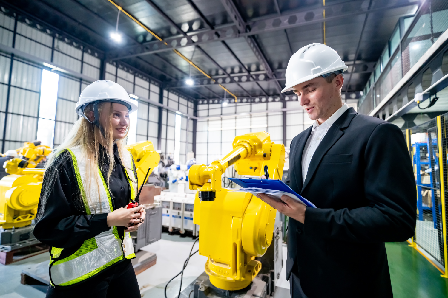 A business professional and a manufacturing facility worker during inspections.