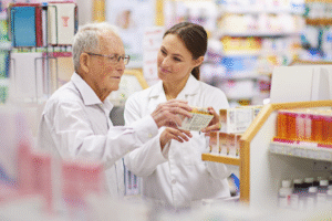Pharmacist helping elderly customer choose dietary supplements at a retail store.