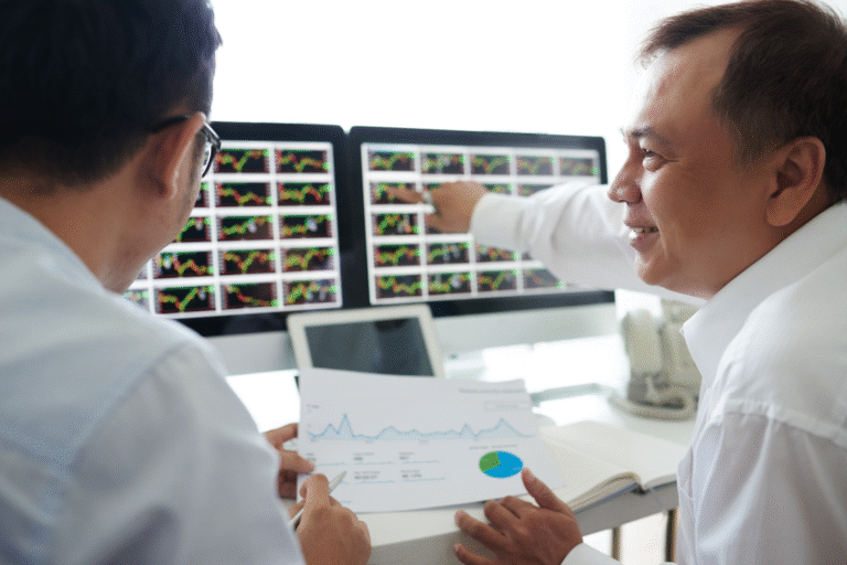 Business professionals reviewing stock charts and financial data during buyer due diligence