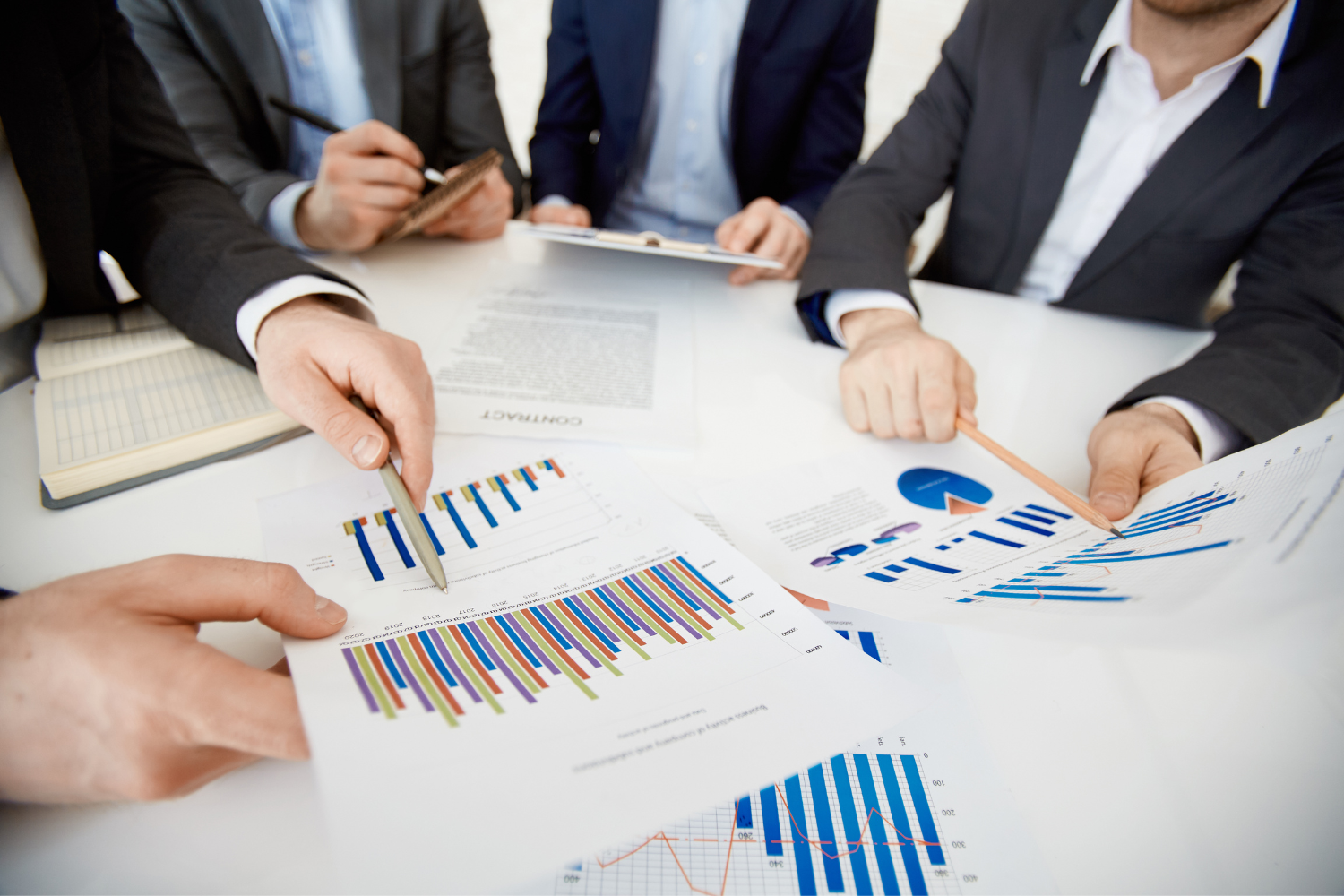 Professionals comparing barg graphs and charts.