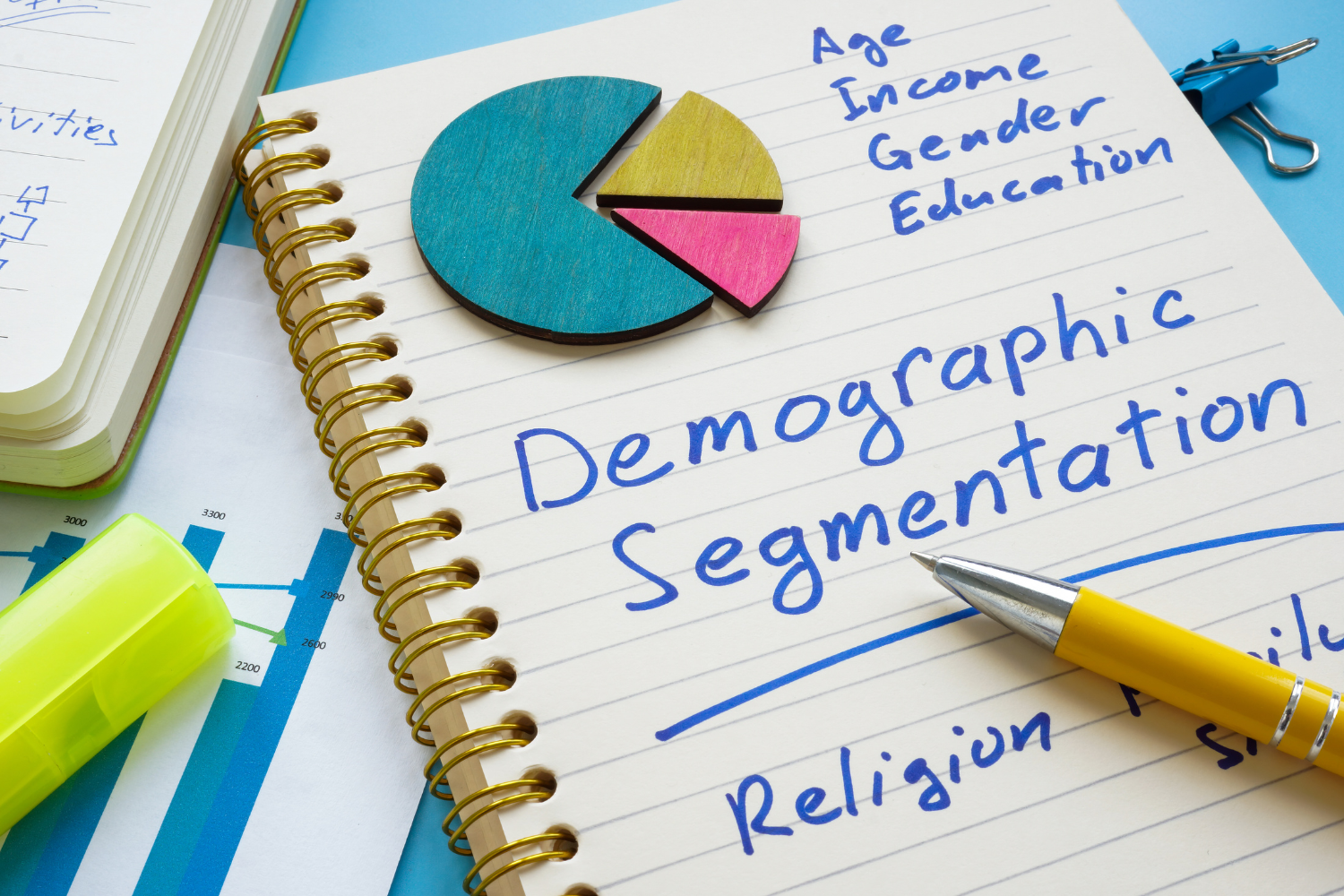 Notebook with demographic segmentation written on it.