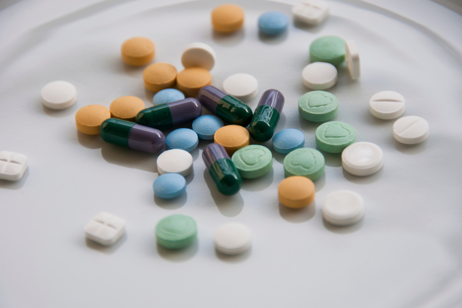 Various types of vitamins on a white surface.