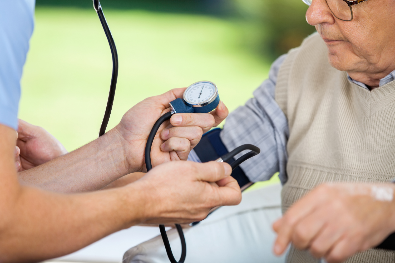 Healthcare professional checking blood pressure of an elderly.