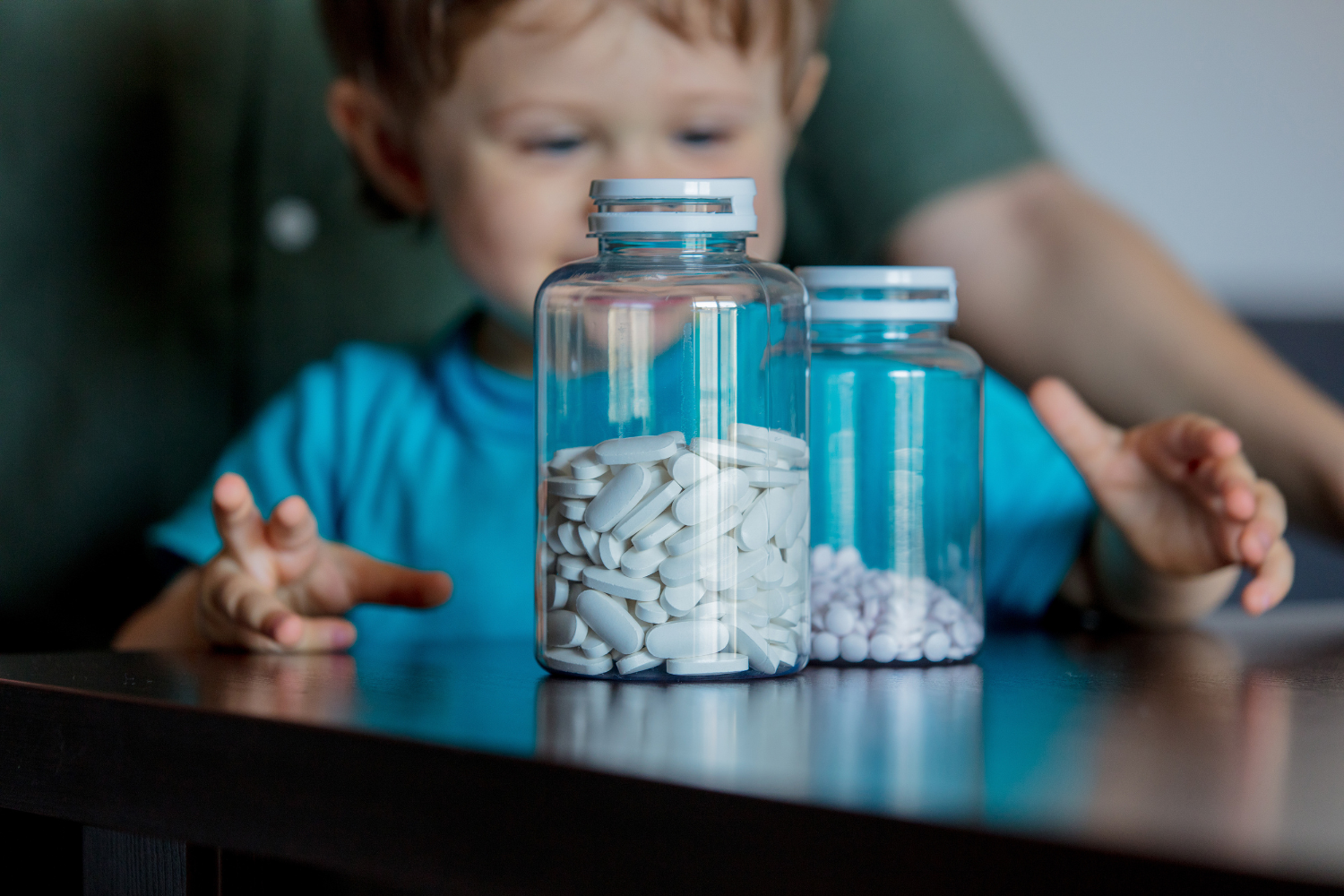 Child looking at supplements inside a transparent bottle.