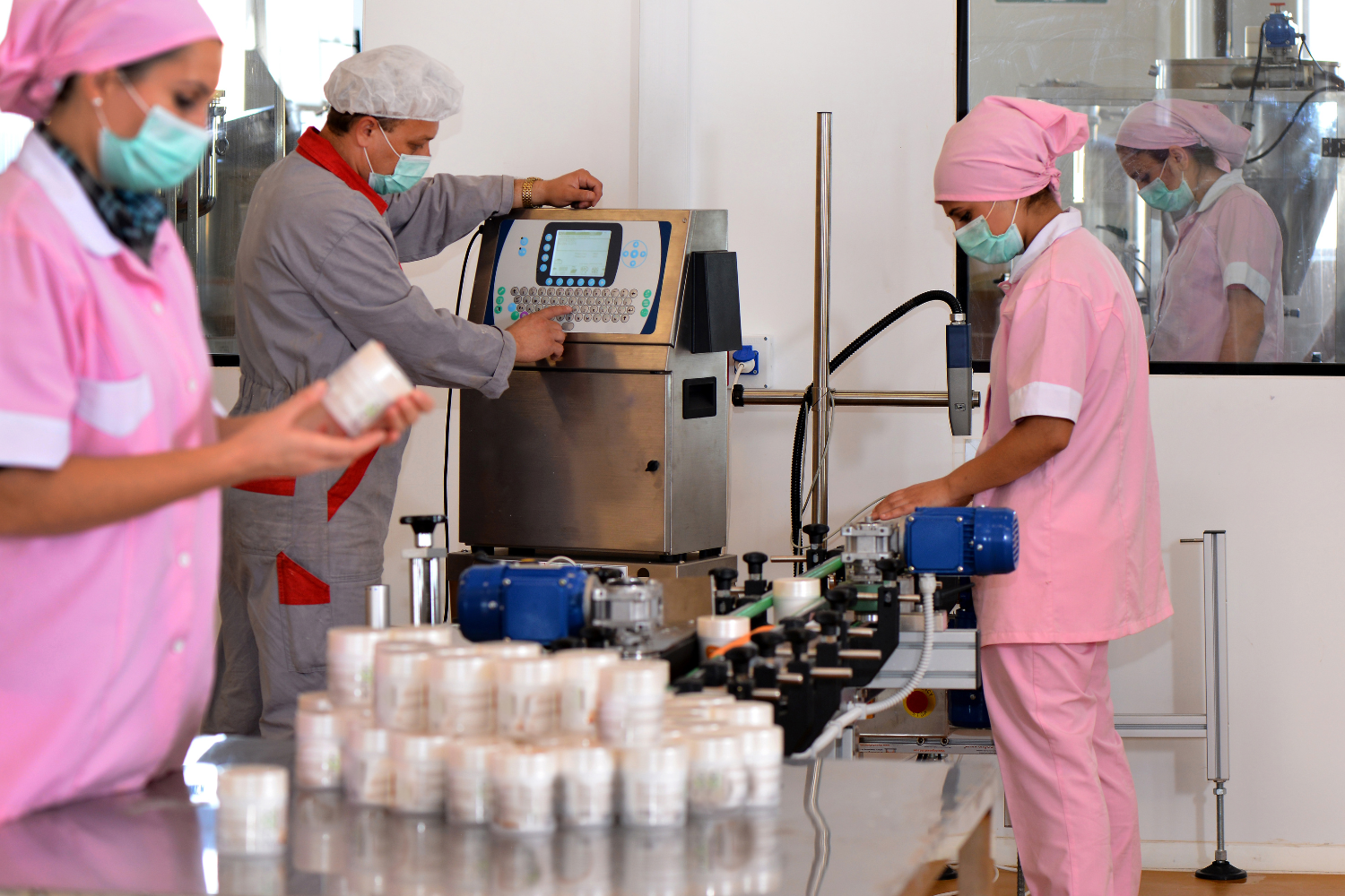 Factory workers monitoring the production line of sports nutrition supplements.