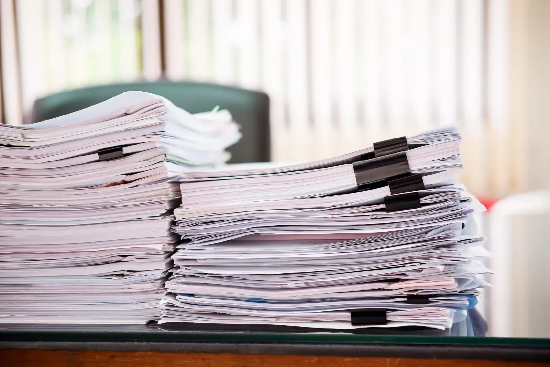 Stacks of manufacturing documentation used for supplement evaluation