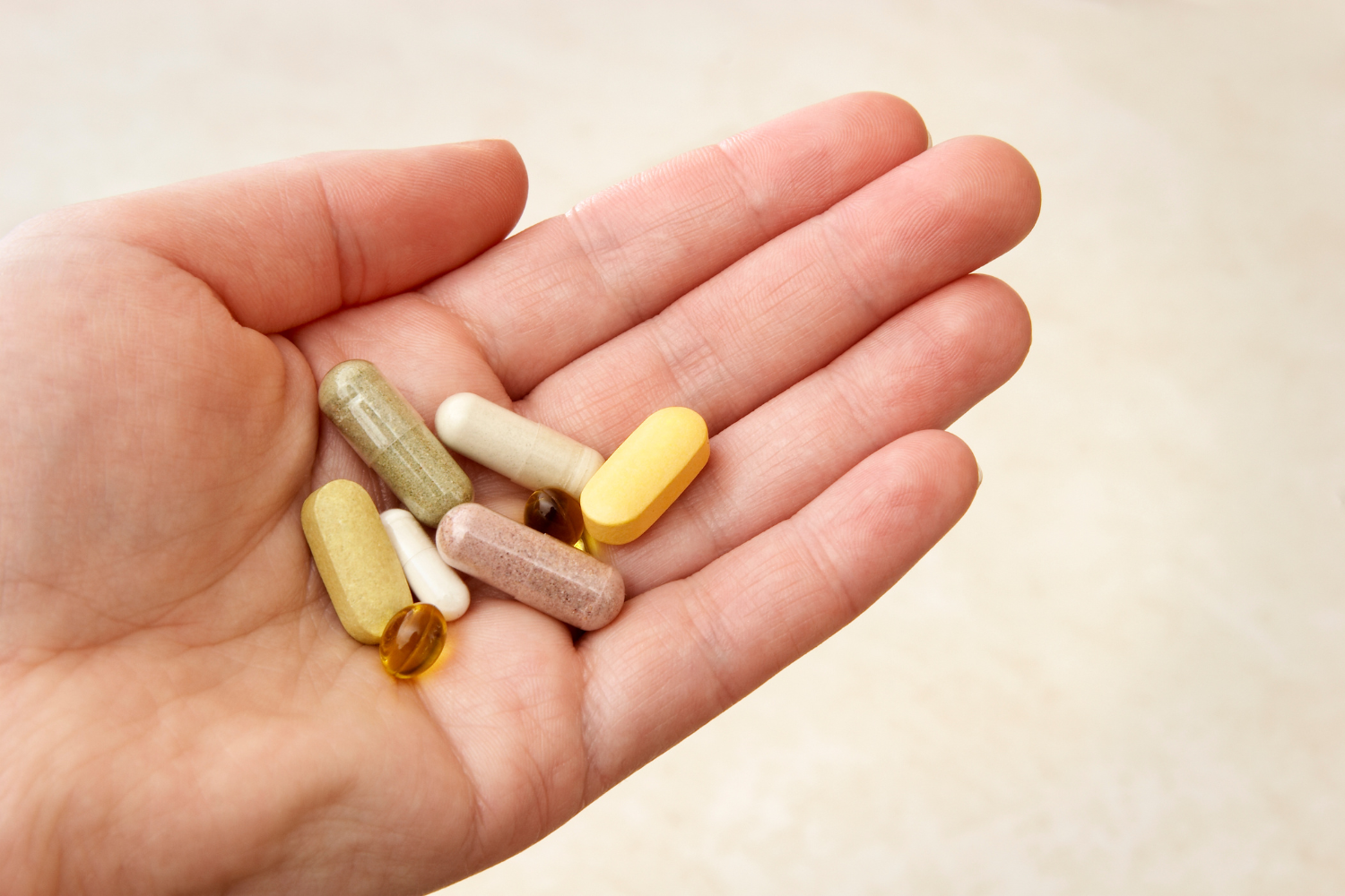 A palm holding several supplements.