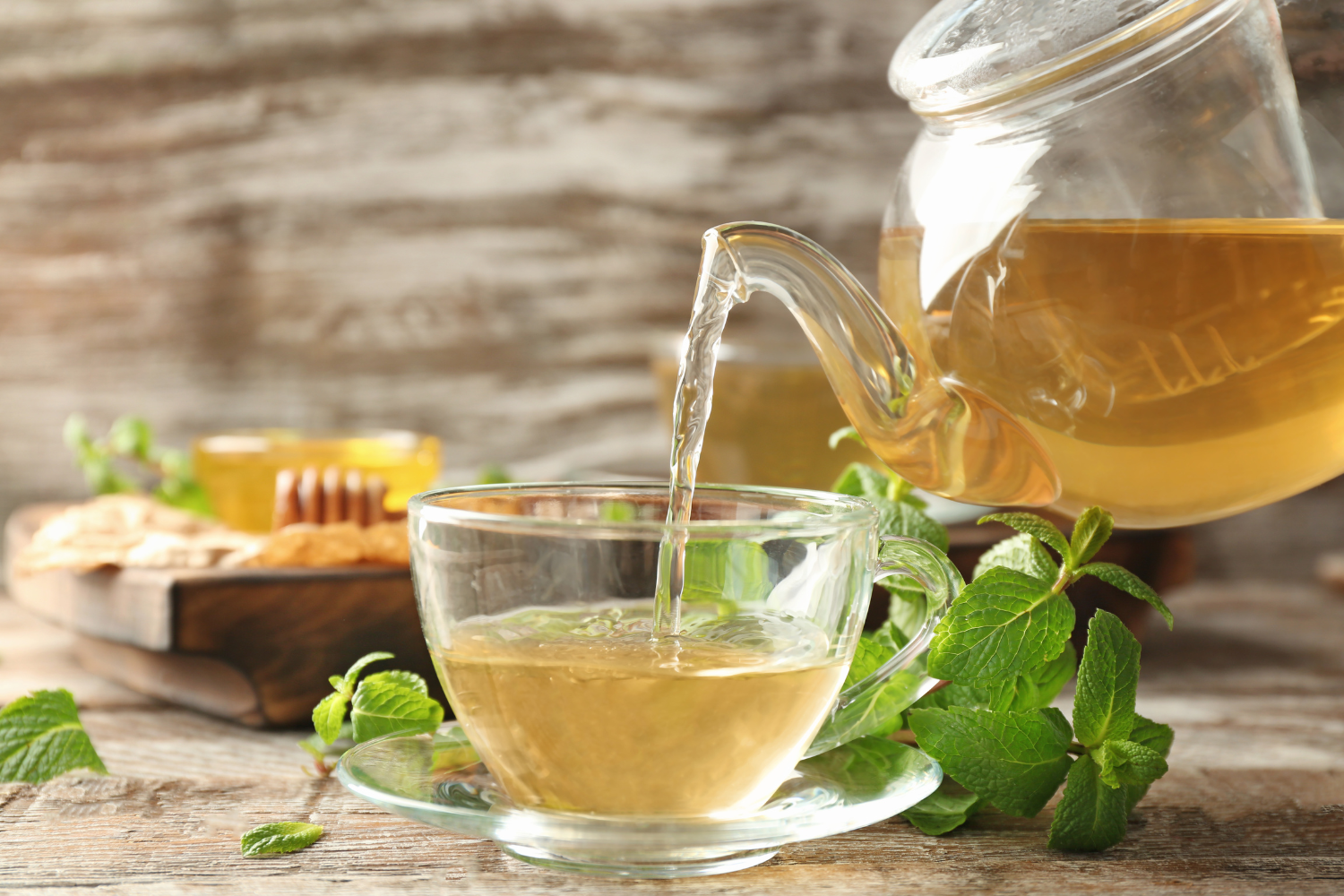 A herbal tea cup with a lemon balm leaf.