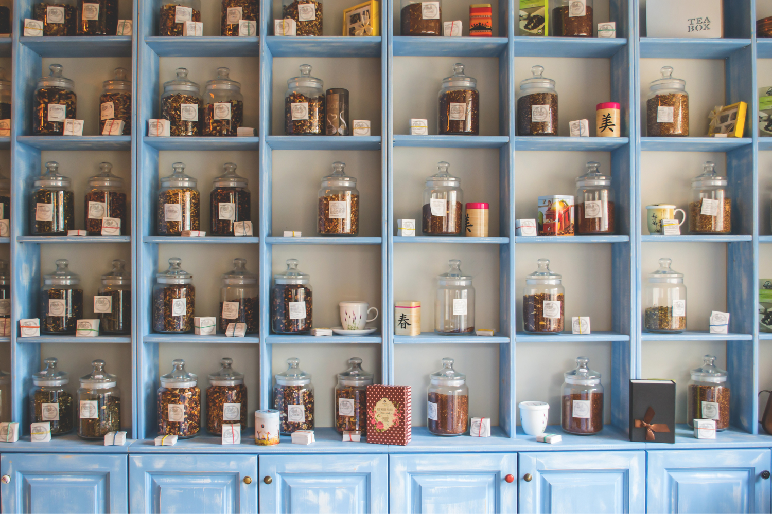 A small-scale tea production setup with tea bags, packaging machines, and storage shelves.
