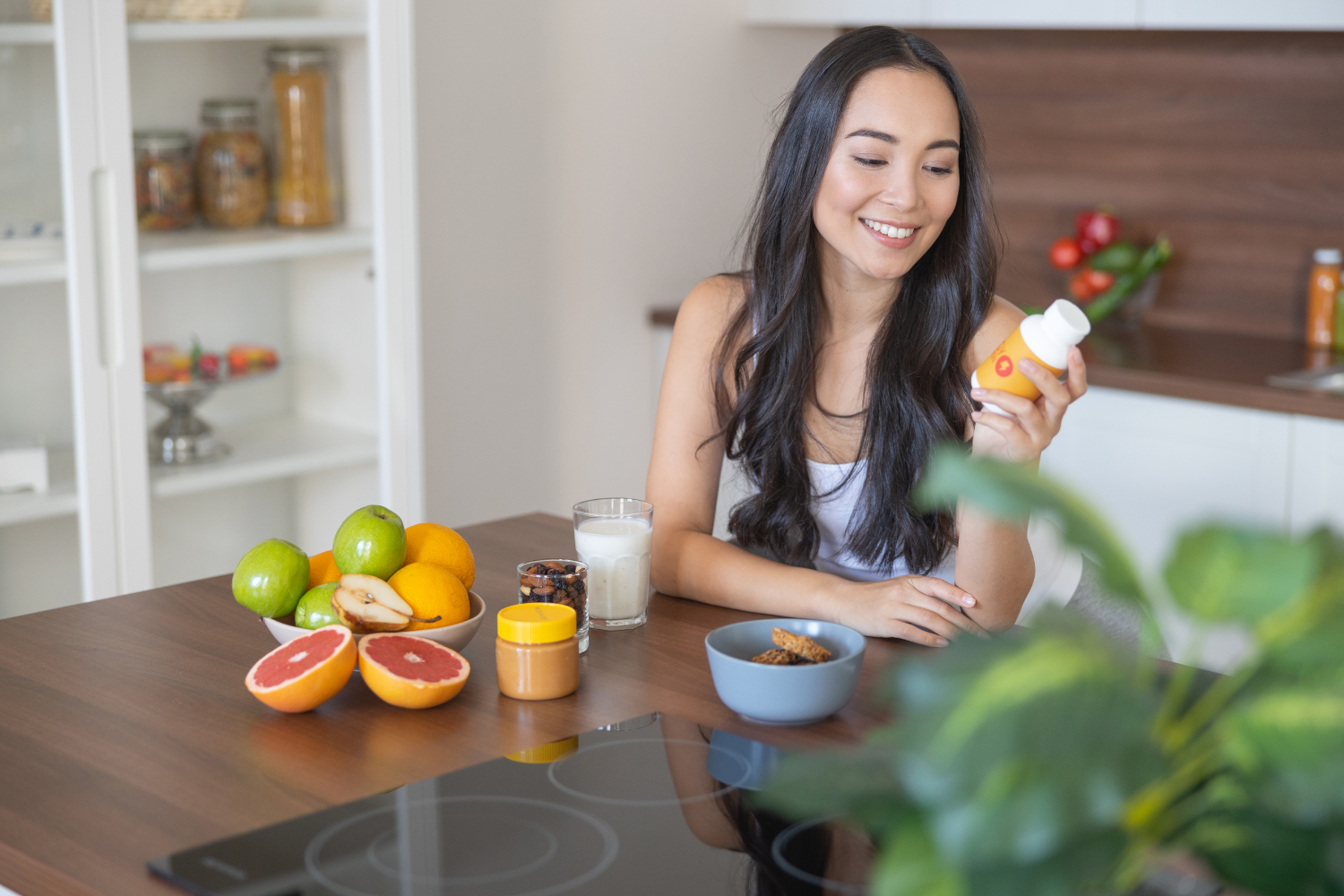 Consumer holding a supplement bottle while smiling.