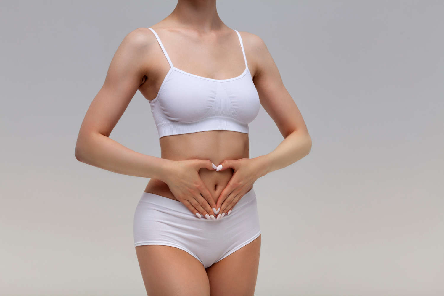 Woman forming a heart on her stomach, depicting gentler digestion.
