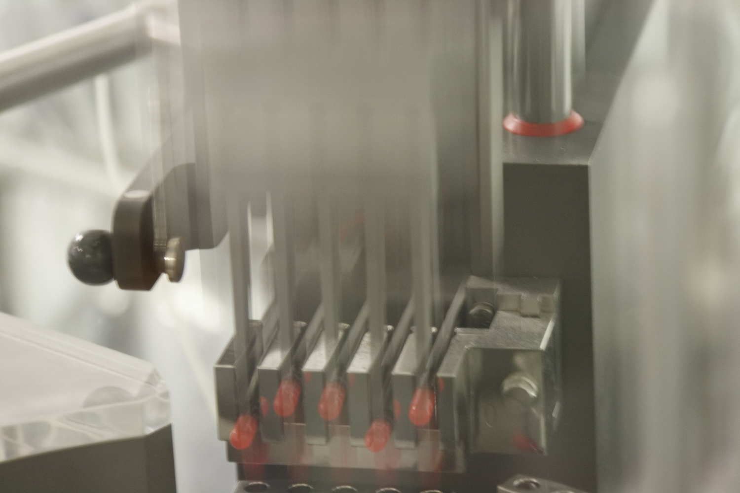 Machines filling capsules into bottles and applying labels.