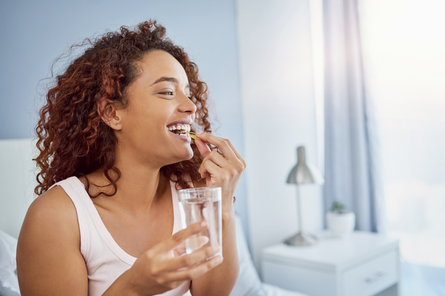 Person taking her multivitamin.
