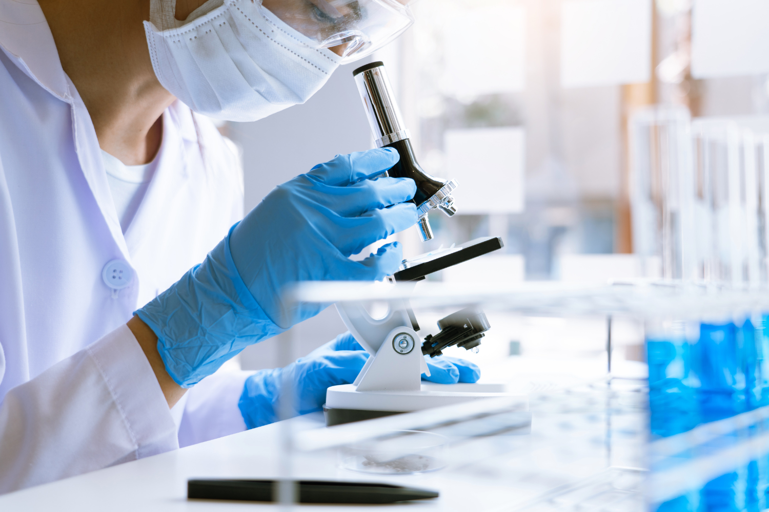 A scientist looking through a microscope.