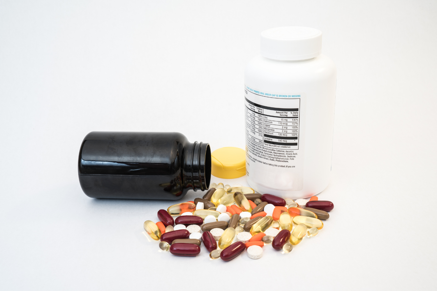 Supplement bottles with supplements on a white surface.