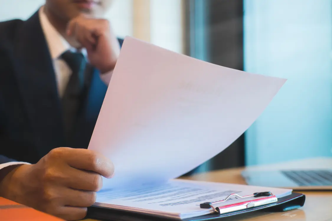 Person reviewing supplement manufacturing documents at a desk