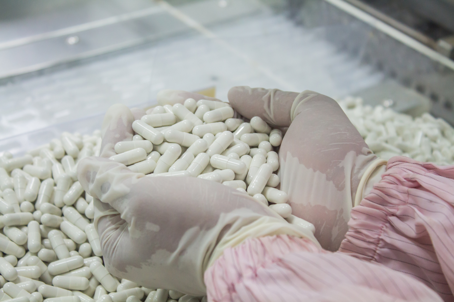 Factory worker scooping newly produced supplements.
