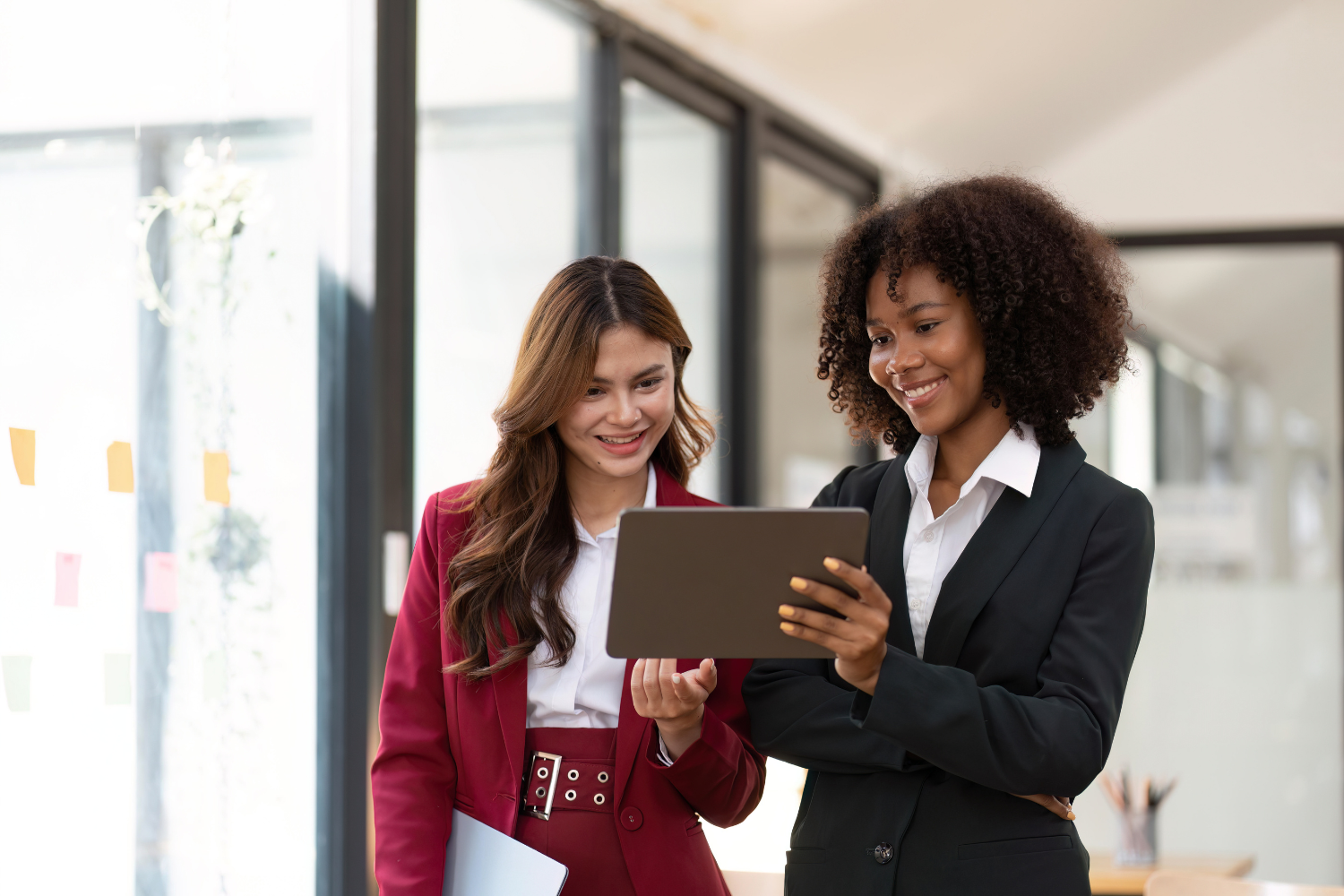 Two professionals checking a digital marketing plan on a tab.
