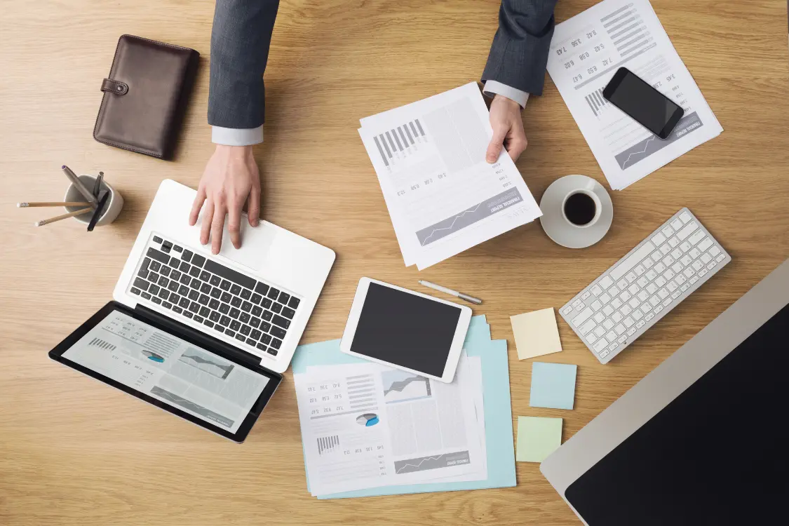 Business professional comparing supplement manufacturers using documents and scorecards