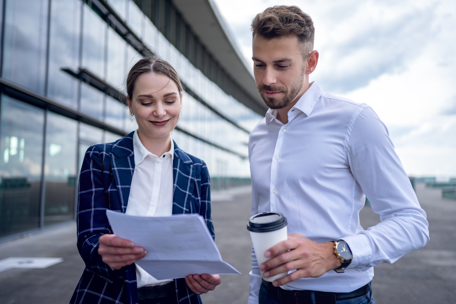 A business owner reviewing a checklist of questions with another business professional.