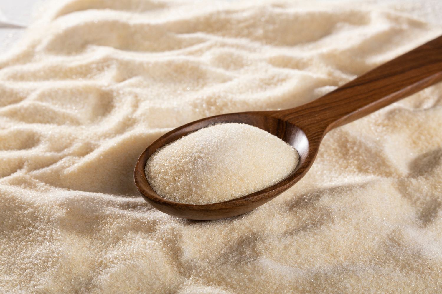 Wooden spoon with grainy brown powder.