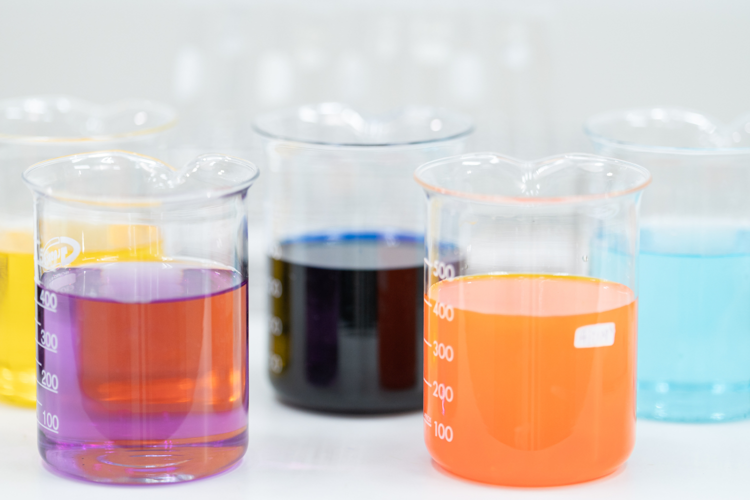 Different colored liquids inside flasks.
