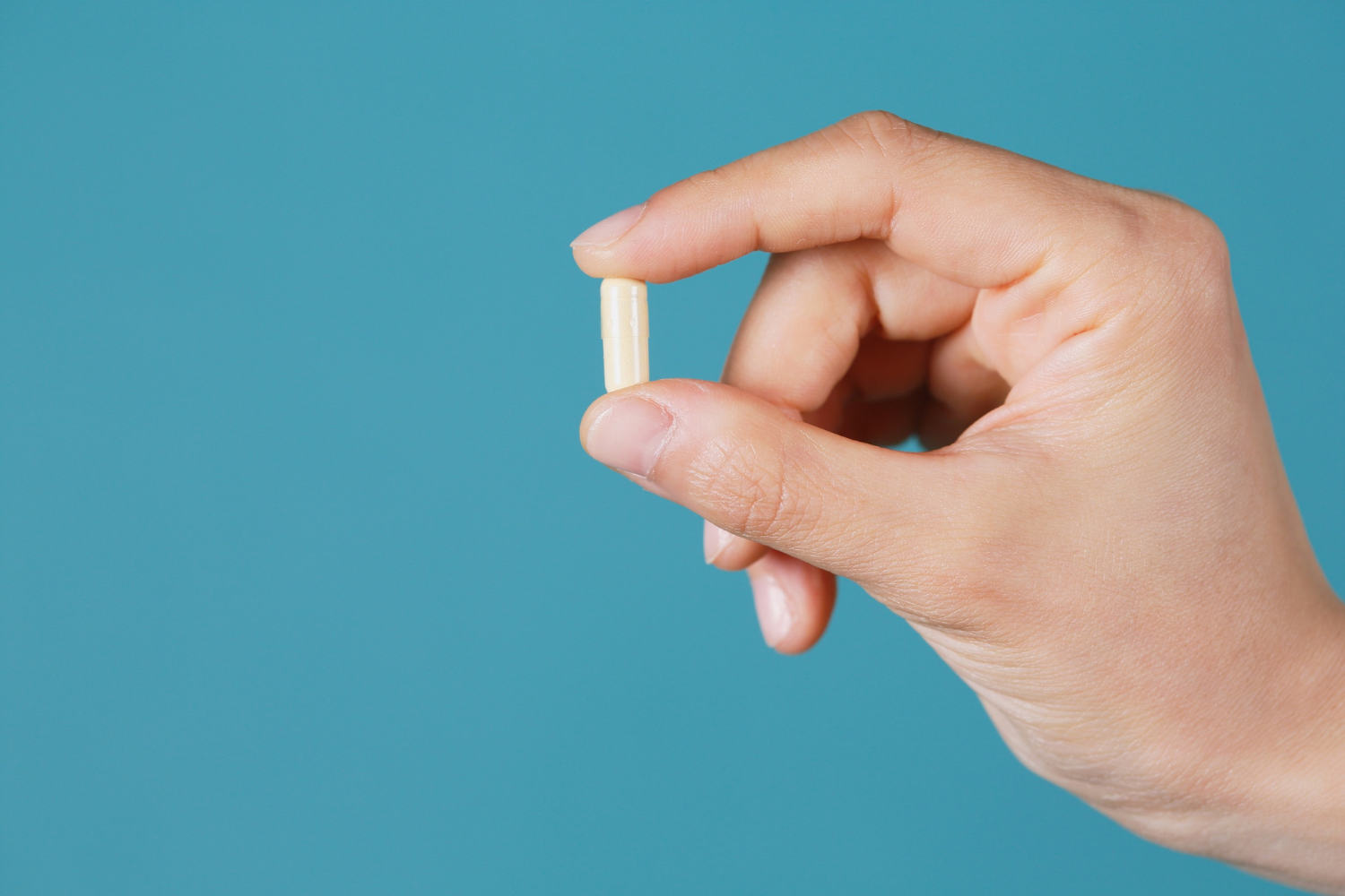 Person holding a capsule.
