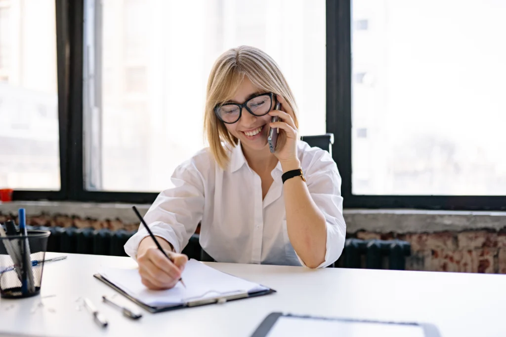 Woman on phone taking notes about supplement manufacturer ownership structure