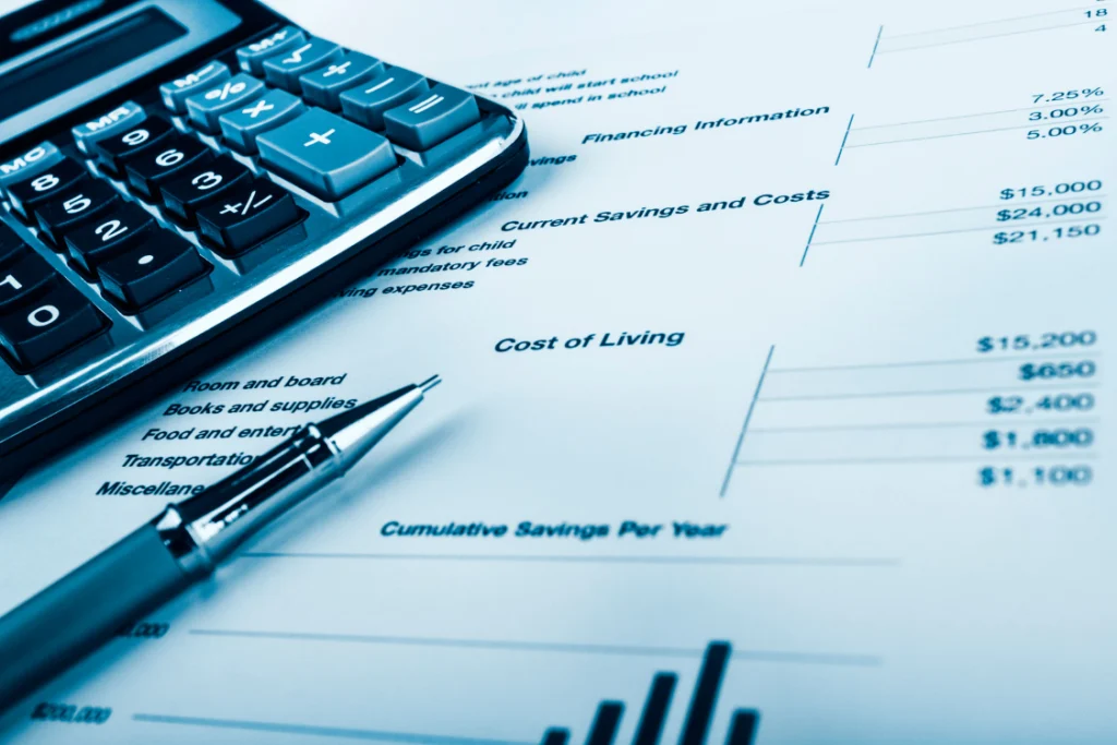 Calculator and financial chart showing cost of living analysis for a switch manufacturer cost savings calculator.