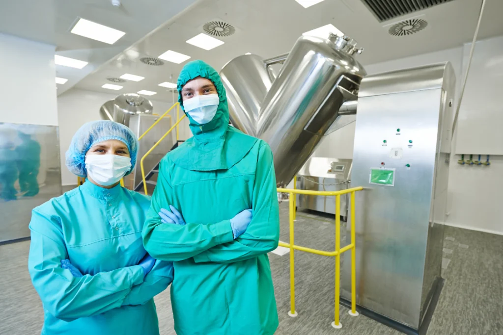 Workers in protective clothing inside supplement manufacturer quality control lab