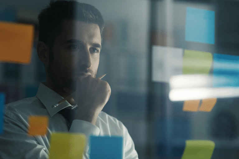 A focused entrepreneur considering strategy, looking at colored sticky notes on a glass wall, illustrating the planning phase for a low MOQ supplement manufacturer partnership.
