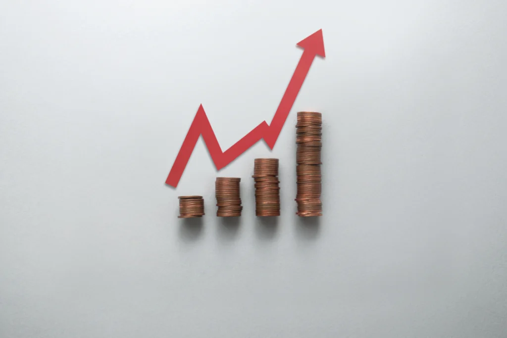 A bar chart made of stacked coins, with a red arrow pointing up, representing rising profit margins and growth enabled by independent pricing per SKU in supplement manufacturing.