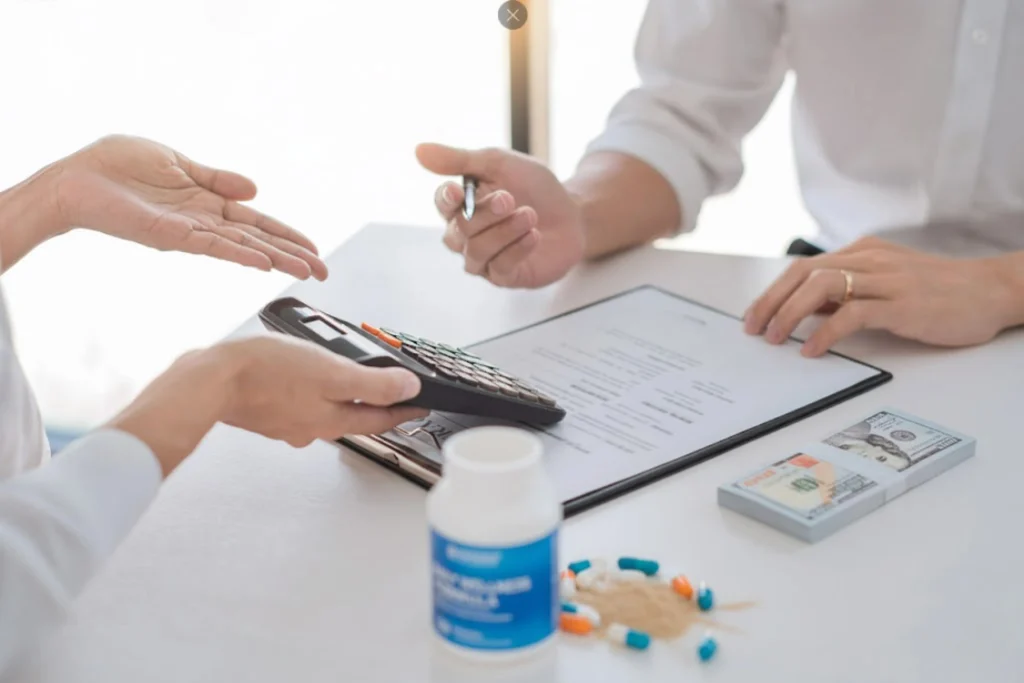 Two people negotiating a contract; one is pointing to a document while the other holds a calculator, symbolizing a detailed, itemized cost breakdown from a supplement manufacturer to ensure fair independent pricing.
