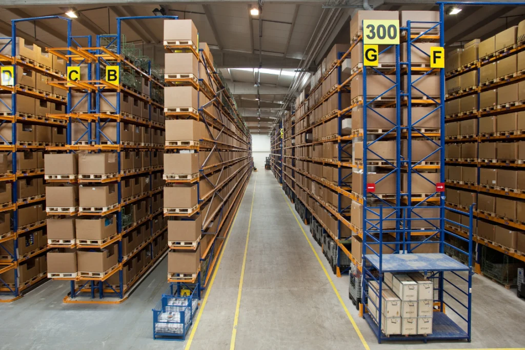 Wide shot of a large, high-bay supplement logistics warehouse with multiple aisles of pallet racks filled with boxed supplements, illustrating efficient storage and 3PL partner fulfillment.
