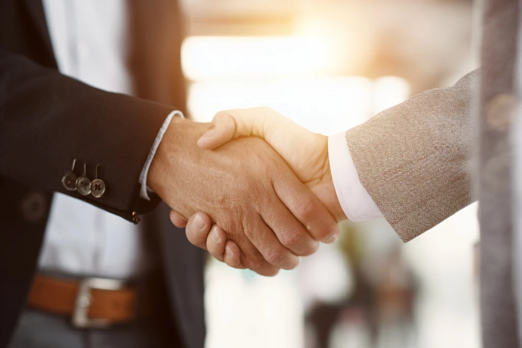 A handshake between two business professionals, symbolizing the successful negotiation of supplement manufacturer pricing and MOQ terms.