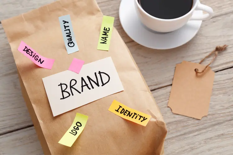 A coffee bag with sticky notes that highlight key elements of a supplement brand identity, including BRAND, QUALITY, LOGO, and DESIGN.