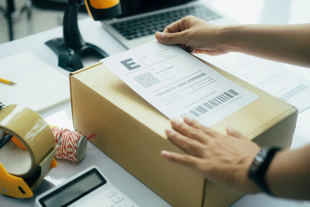 Hands placing a 'Priority Mail Express' shipping label onto a dropshipping box, emphasizing the logistics of private label dropshipping supplements.